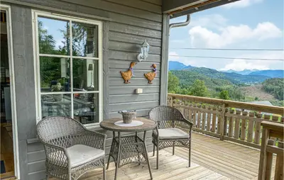 a porch with three chairs and a table on a deck at Gorgeous Home In Øydegard in Nastad