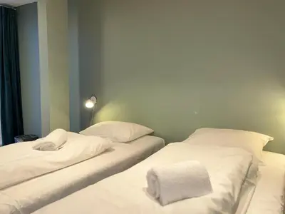 two beds in a room with white sheets and towels at Winjum Hostel Stegastein in Aurland