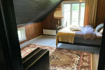 a bedroom with a bed and a large window at Steinsvoll Gård in Vang I Valdres