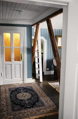 a hallway with a door and a rug at Sylte Hotell, Valldal in Valldal