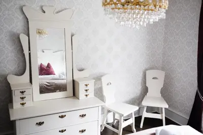 a bedroom with a white dresser and two white chairs at Sylte Hotell, Valldal in Valldal