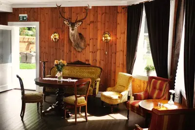 a room with a table and a deer head on the wall at Sylte Hotell, Valldal in Valldal