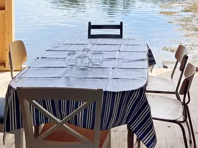 a table with glasses and chairs next to a body of water at 8 person holiday home in Halsanaustan-By Traum in Korsnes