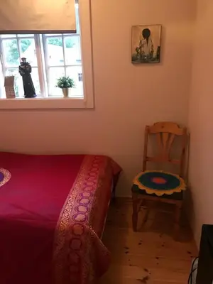 a bedroom with a bed and a chair and a window at Dr Haave- middle of nowhere, pikeværelset in Sand