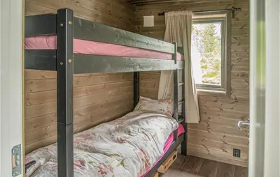 a bunk bed in a log cabin with a window at Awesome Home In Rena With Wifi in Rena