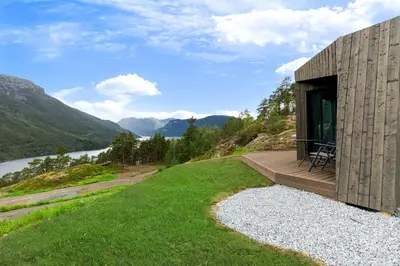 a house on a hill with a view of a river at Sogndal Fjordpanorama - Studio Cabins With View in Sogndal