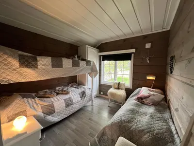 a bedroom with two bunk beds and a window at Beitostølen sentralro in Beitostøl