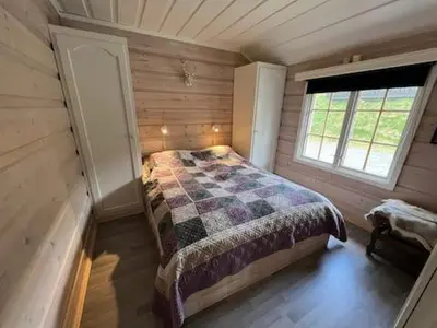 a bedroom with a bed in a wooden cabin at Beitostølen sentralro in Beitostøl