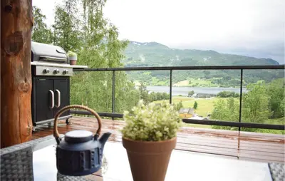 a balcony with a stove and a view of a lake at 3 Bedroom Stunning Home In Vossestrand in Vossestrand