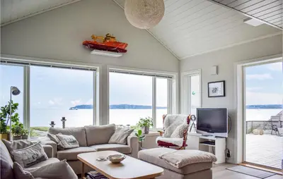 a living room with a couch and a tv at Nice Home In Sveio With House Sea View in Sveio