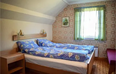 a bedroom with a bed with blue sheets and a window at Awesome Home In Fitjar With Wifi in Fitjar