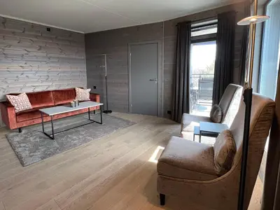 a living room with a couch and a table at Riddertunets moderne in Beitostøl