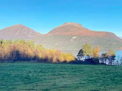 a field with a lake and mountains in the background at 6 person holiday home in Halsanaustan-By Traum in Korsnes