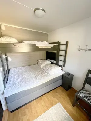 a bedroom with two bunk beds and a chair at Mountain retreat in Uvdal WIFI SAUNA in Uvdal