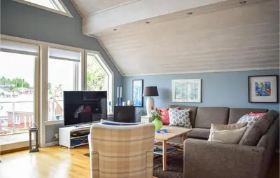 a living room with a couch and a tv at 4 Bedroom Gorgeous Home In Herdla in Herlø