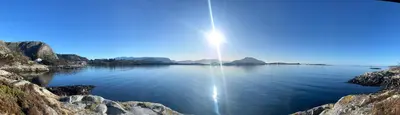 a large body of water with the sun in the sky at Ytterland Apartments in Ålesund