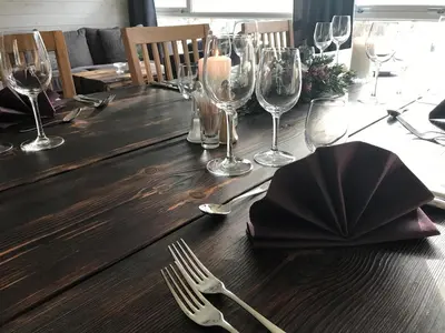 a wooden table with wine glasses and a napkin at Gaupnetunet Hotell og Hytter in Gaupne