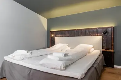 a large white bed with white towels on it at Gaupnetunet Hotell og Hytter in Gaupne