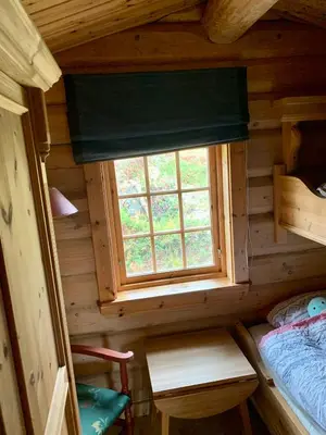 a small bedroom with a window in a log cabin at Timber Lodge in Uvdal Skisenter VIEW/WIFI in Sønstebø