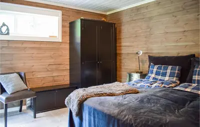 a bedroom with a bed and a chair and a window at Lovely Home In Vossestrand With Wifi in Vossestrand