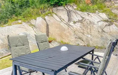 a black table with two chairs and a white vase on it at 4 Bedroom Nice Home In Stangvik in Stangvik