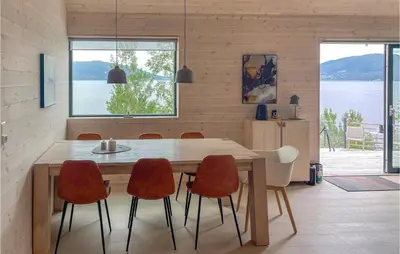 a dining room with a wooden table and chairs at 4 Bedroom Nice Home In Stangvik in Stangvik