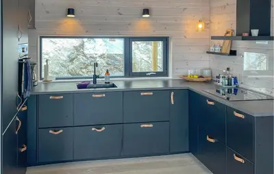 a kitchen with blue cabinets and a sink at 4 Bedroom Nice Home In Stangvik in Stangvik