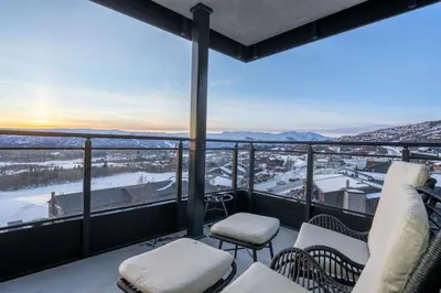 a balcony with chairs and a view of a city at Riddertunets luksuriøse in Beitostøl