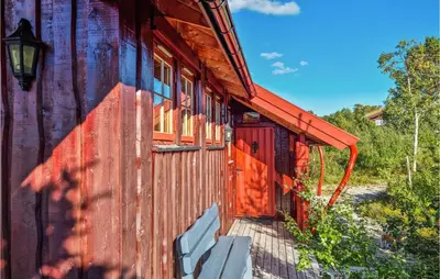 a red door on the side of a wooden building at Nice Home In Hovden I Setesdalen in Hovden