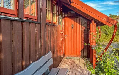 a wooden house with a wooden door and a bench at Nice Home In Hovden I Setesdalen in Hovden