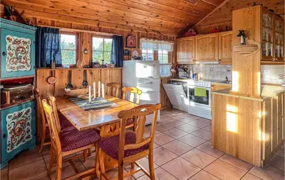 a kitchen with a table and a refrigerator at Nice Home In Hovden I Setesdalen in Hovden