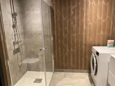 a shower with a glass door in a bathroom at New apartment, Gausta in Rjukan. Ski in/ ski out in Rjukan