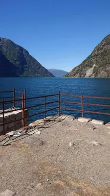 a fence next to a large body of water at Hillegård in Lærdalsøyri