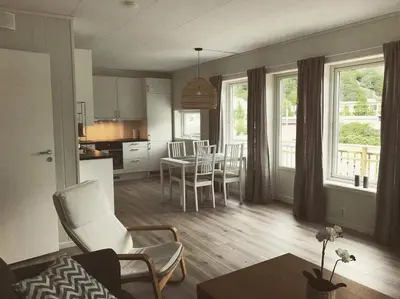 a kitchen and living room with a table and chairs at Hillegård in Lærdalsøyri