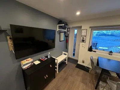 a living room with a large flat screen tv on the wall at Great place with a stunning view of the mountains and the fjord in Ålesund