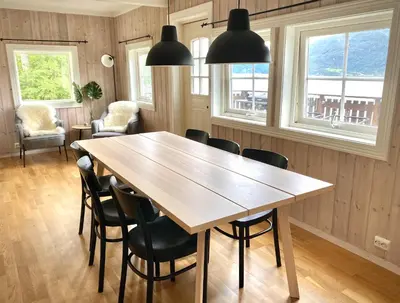 a dining room with a wooden table and chairs at Stryn - Faleide -hytte med fjord og fjell utsikt in Stryn