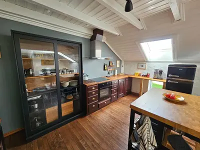 a large kitchen with wooden floors and a large window at Sigurd's Loft in Vossevangen