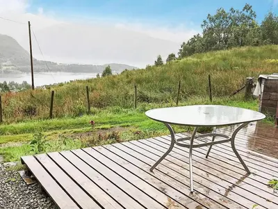 a table on a wooden deck with a view of the water at 4 person holiday home in Bryggja-By Traum in Bryggja
