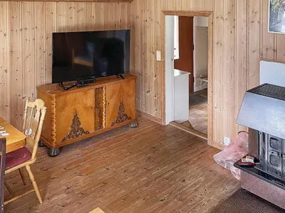 a living room with a large television and a wooden floor at 4 person holiday home in Bryggja-By Traum in Bryggja