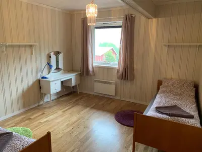 a room with two beds and a desk and a window at Feriehus med utsikt til fjord og fjell in Gvammen