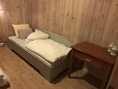 a small bed in a room with a table at Feriehus med utsikt til fjord og fjell in Gvammen
