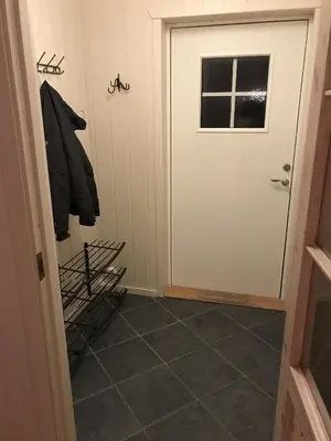 a hallway with a door and a tiled floor at Feriehus med utsikt til fjord og fjell in Gvammen