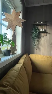 a living room with a couch and a star hanging from a window at Sanderstølen Hytte in Tisleidalen