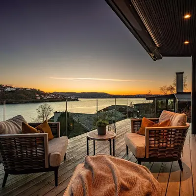 a deck with chairs and a view of the water at 