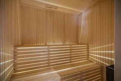 a wooden sauna with the light shining on the wall at NEW LUXUARY Cabin with perfect location on Geilo. in Flatåker