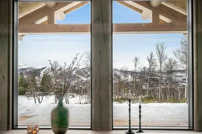a window with a vase and two umbrellas at NEW LUXUARY Cabin with perfect location on Geilo. in Flatåker