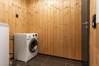 a washing machine in a room with a wooden wall at Gaustablikk Hytte - MountainView in Gaustablikk