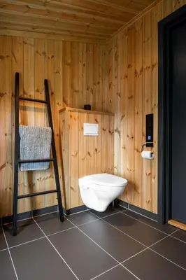 a bathroom with a toilet in a wooden wall at Gaustablikk Hytte - MountainView in Gaustablikk