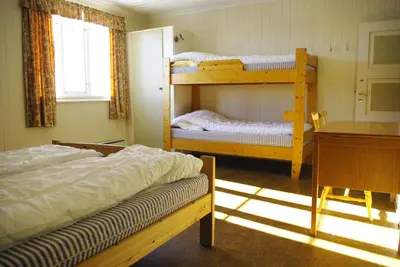 a bedroom with two bunk beds and a desk at Svarteberg Drengestugu - cabin by Ål skisenter in Ål