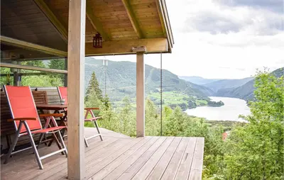 a porch with chairs and a table with a view of a river at Beautiful Home In Vossestrand With Wifi in Vossestrand
